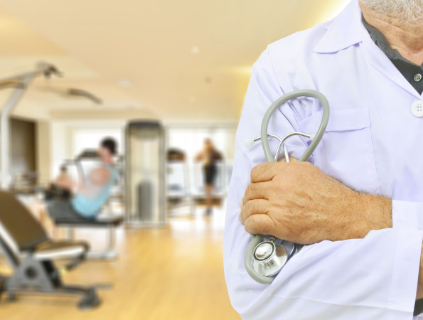 Metge davant d'una sala d'exercicis d'un gimnàs