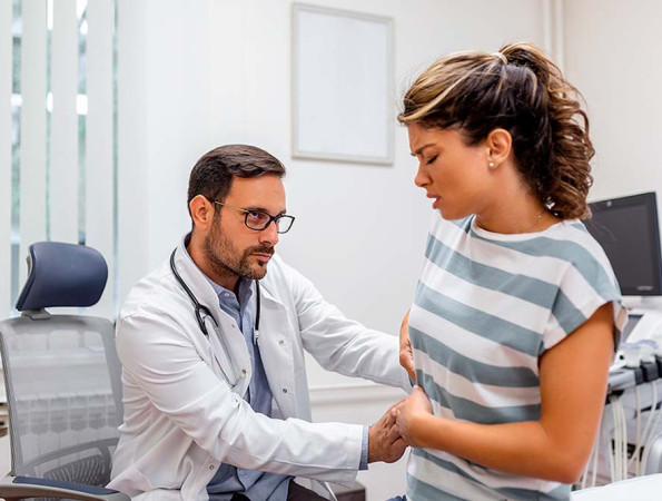 Metge fent un reconeixement a una pacient amb dolor a la part superior dreta de l'abdomen