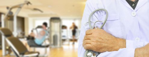 Metge davant d'una sala d'exercicis d'un gimnàs