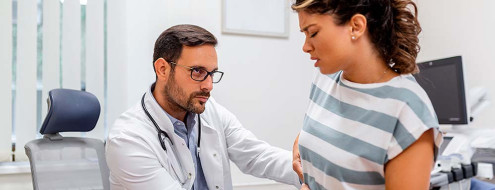 Metge fent un reconeixement a una pacient amb dolor a la part superior dreta de l'abdomen