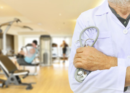 Metge davant d'una sala d'exercicis d'un gimnàs