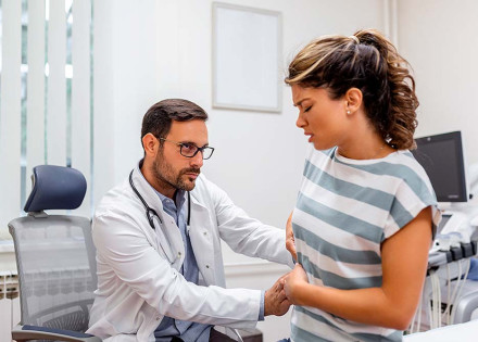 Metge fent un reconeixement a una pacient amb dolor a la part superior dreta de l'abdomen