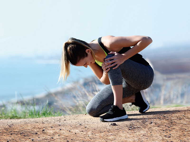 Mujer haciendo deporte tocándose la rodilla