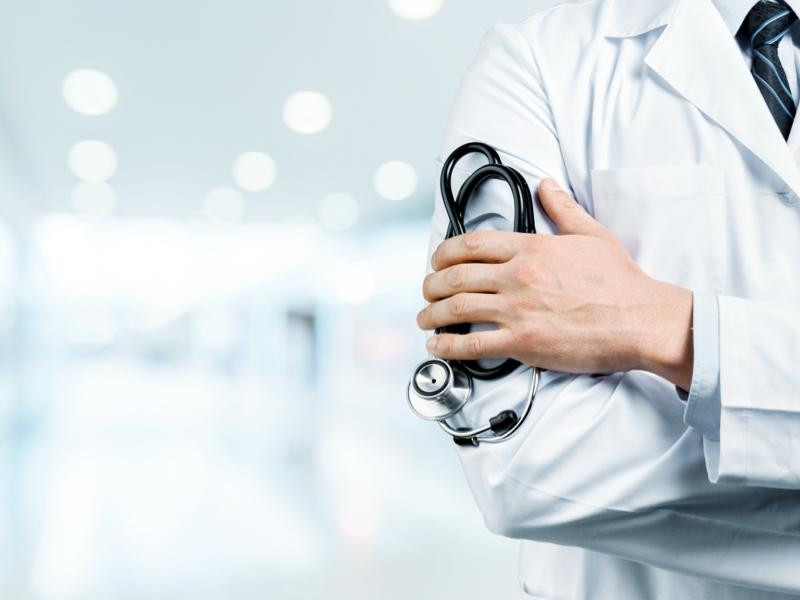 Médico con estetoscópio en la mano