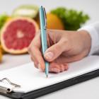 médicoo apuntando notas con pomelos de fondo